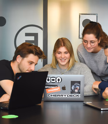 Equipo de trabajo reunido frente a una computadora